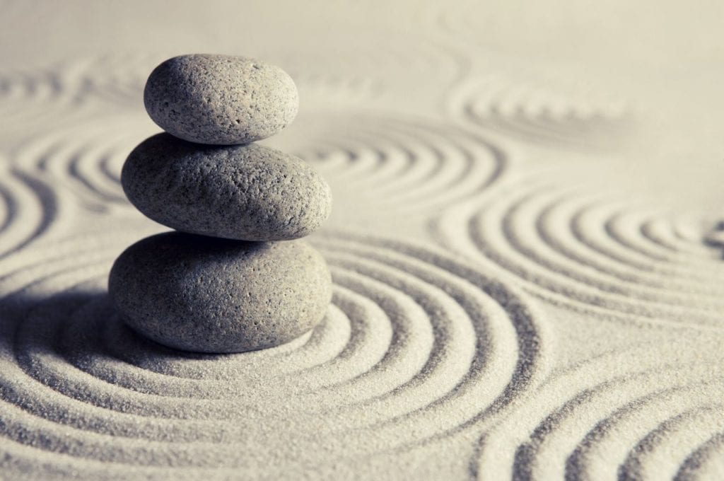 Stones balancing on sand.