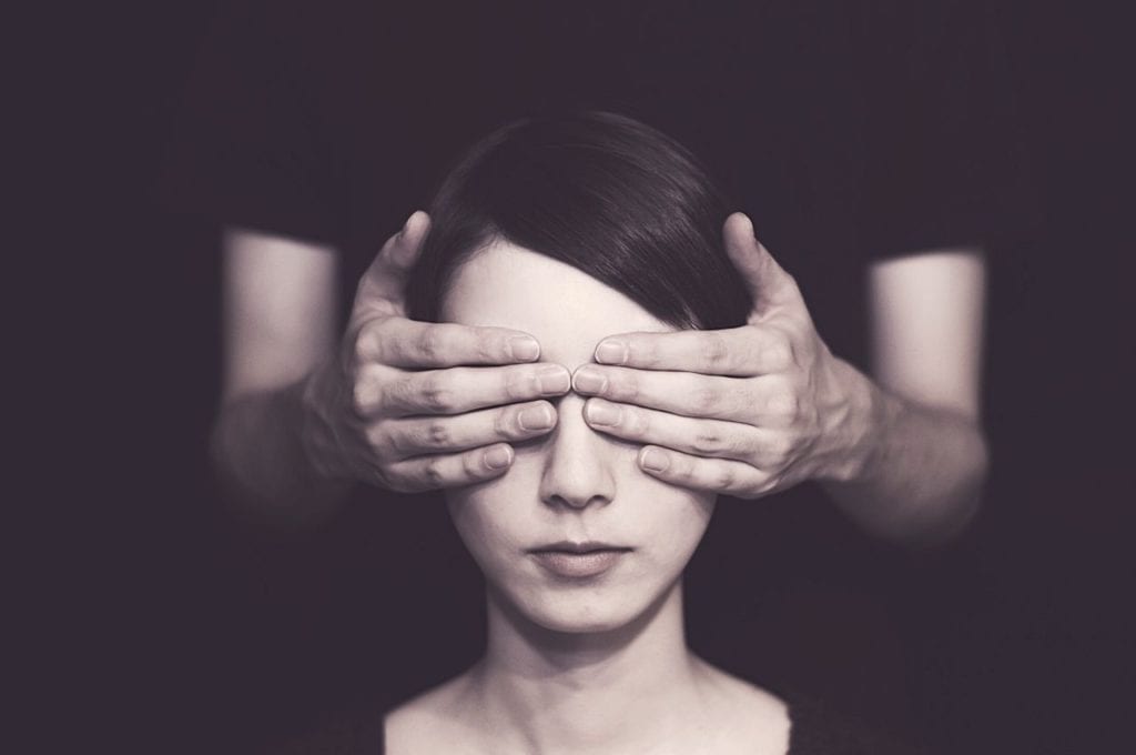 A pair of hands cover eyes, representing a blind date.