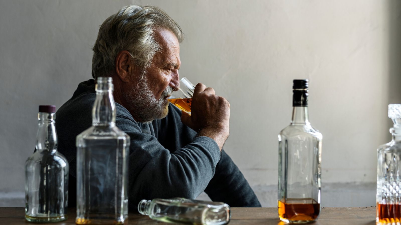 A man with alcohol addiction consumes alcohol.