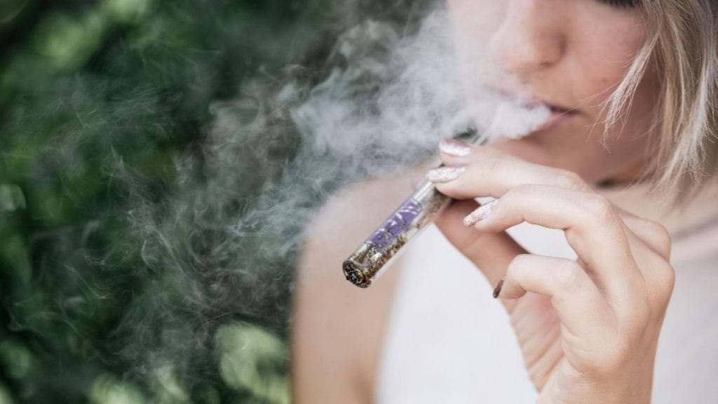 A woman vaping cannabis outdoors