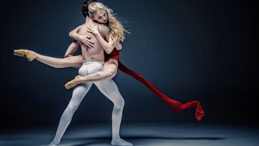 Male and female ballet dancers creating synergy