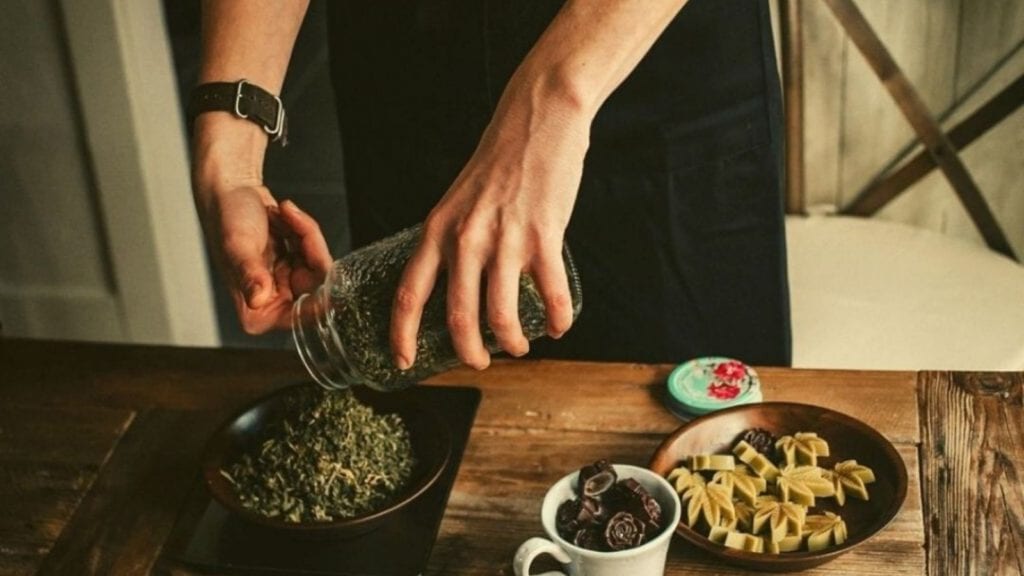 A woman weighs cannabis in preparation for cannabis baking and making cannabutter