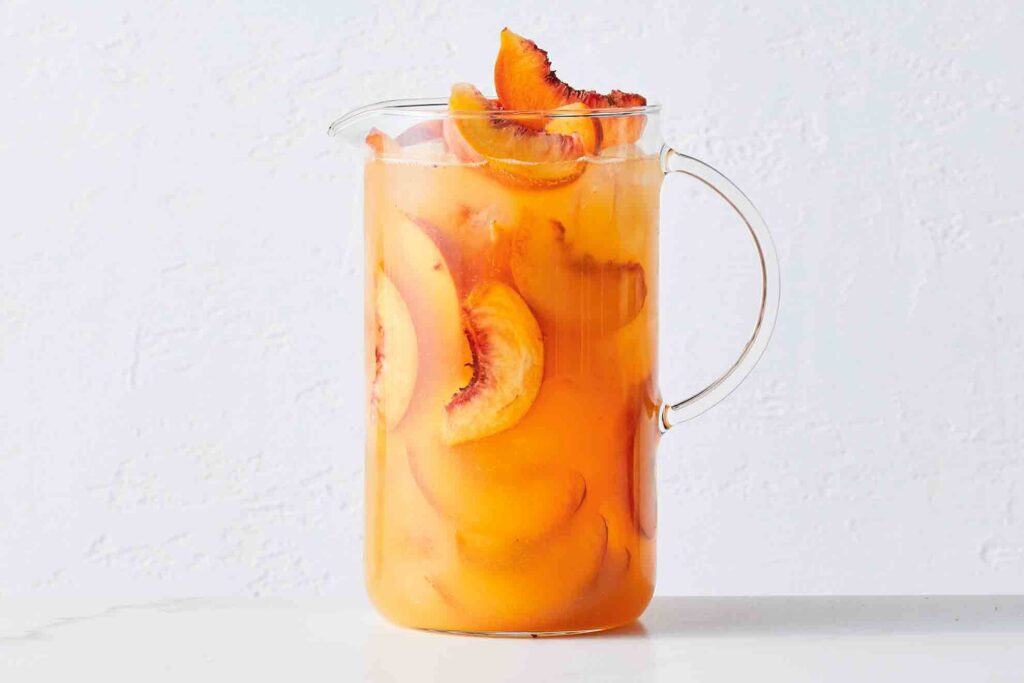 Photograph of a pitcher of mango and peach kombucha bellini for an article on cannabis mocktail recipes